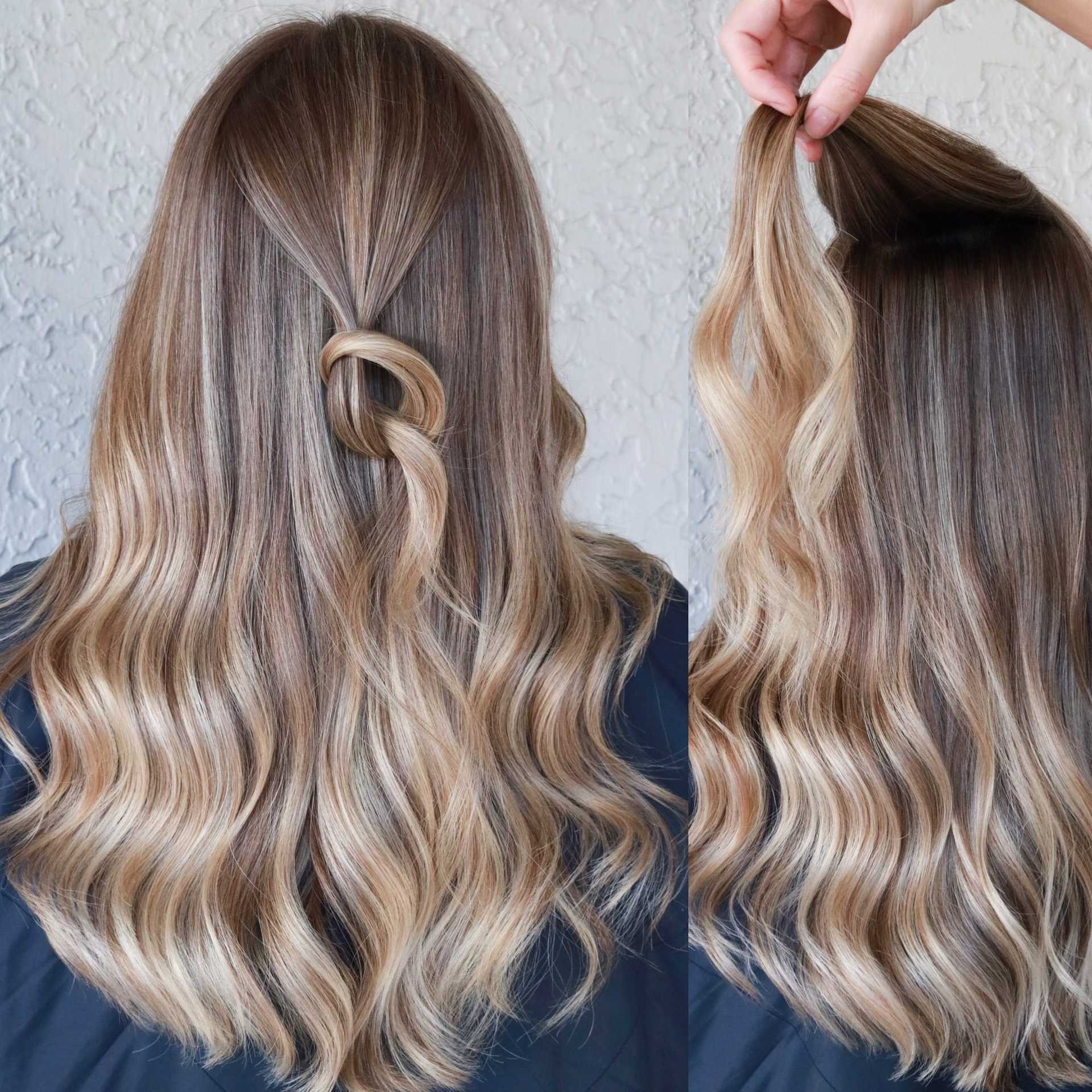 Half-up hairstyle with loose waves and a twisted knot detail.