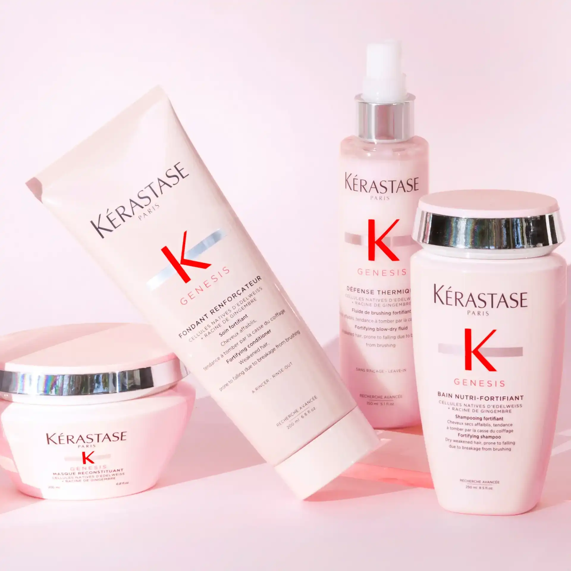 Kérastase Genesis hair care products arranged on a pink background.